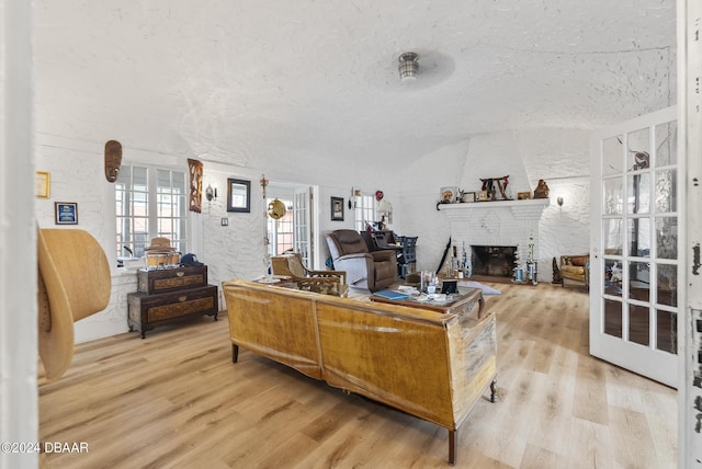 living room with wood finished floors, a fireplace, and a textured ceiling