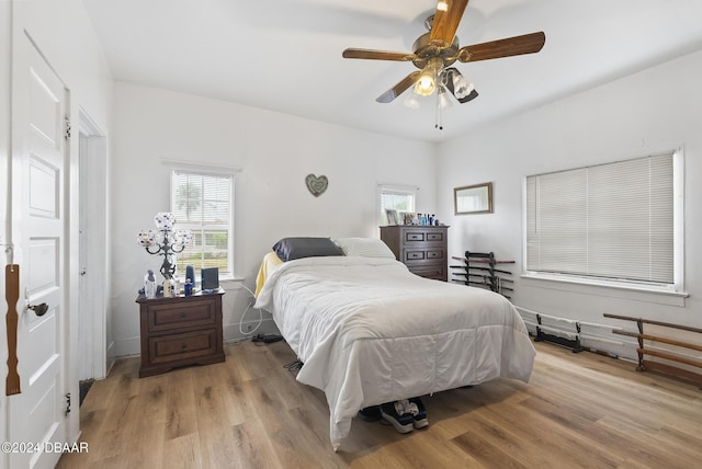 bedroom featuring multiple windows, light wood-type flooring, and a ceiling fan