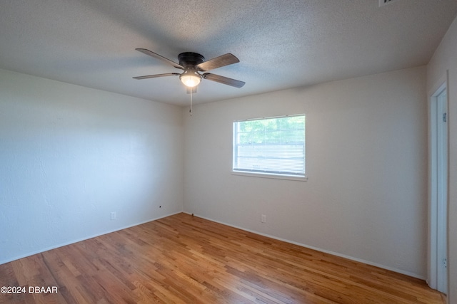 unfurnished room featuring a textured ceiling, light hardwood / wood-style flooring, and ceiling fan