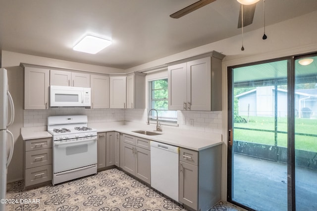 kitchen featuring gray cabinetry, ceiling fan, sink, backsplash, and white appliances