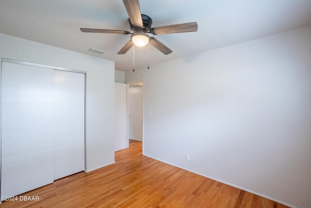 unfurnished bedroom with a closet, ceiling fan, and light hardwood / wood-style flooring