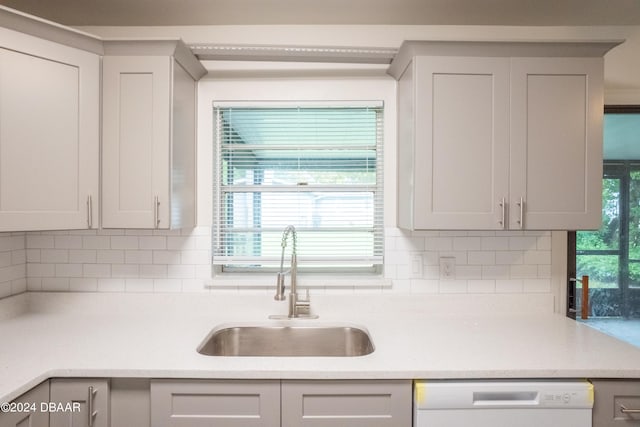 kitchen featuring dishwasher, decorative backsplash, a healthy amount of sunlight, and sink