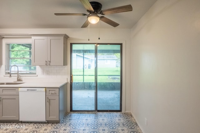 kitchen with decorative backsplash, white dishwasher, plenty of natural light, and sink