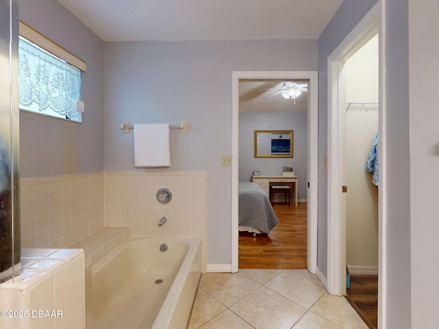 686 Middlebury Loop, New Smyrna Beach, FL 32168 - full bathroom with tile patterned floors, a garden tub, a ceiling fan, a walk in closet, and connected bathroom
