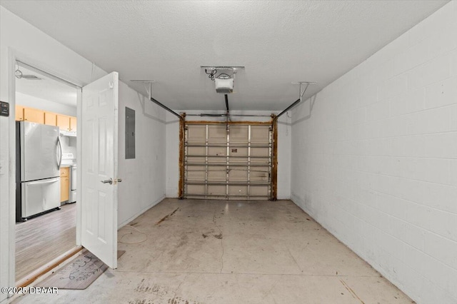 garage with a garage door opener, freestanding refrigerator, electric panel, and concrete block wall