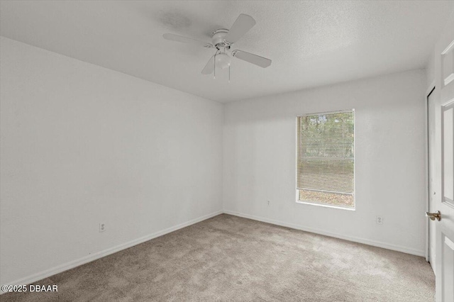 carpeted spare room with ceiling fan, a textured ceiling, and baseboards