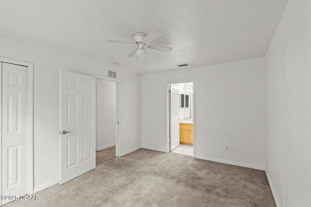 unfurnished bedroom featuring baseboards, visible vents, and light colored carpet