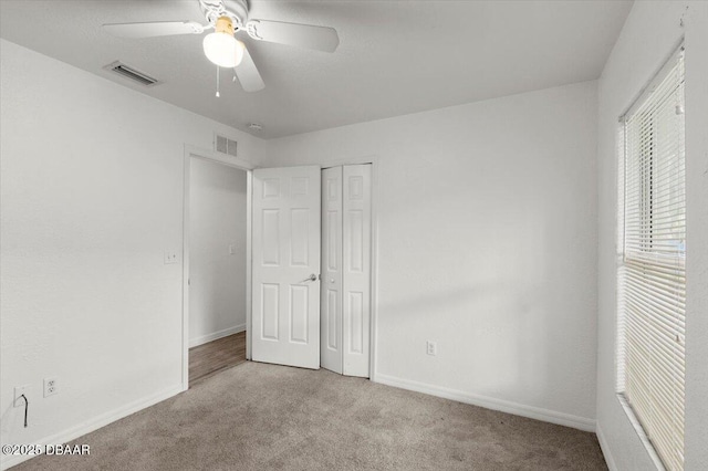 unfurnished bedroom featuring carpet, visible vents, and baseboards