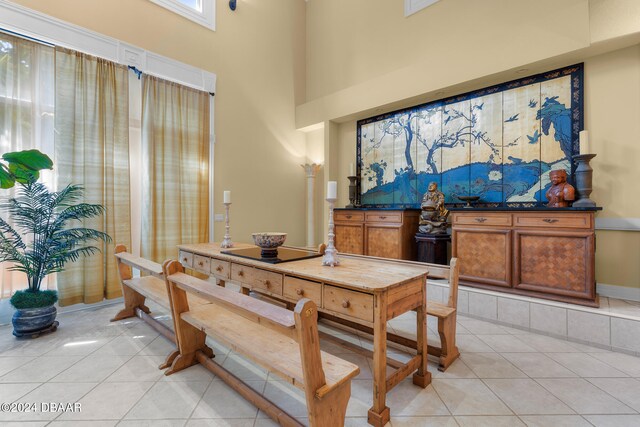 tiled dining space featuring a high ceiling