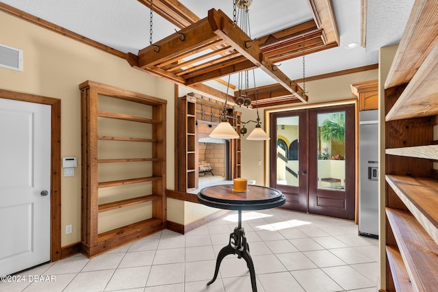 entrance foyer with a textured ceiling, light tile patterned floors, french doors, and ornamental molding