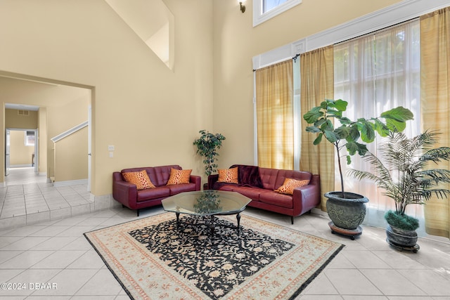 living room featuring light tile patterned flooring and a high ceiling