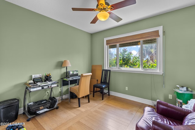 home office with light wood-type flooring and ceiling fan