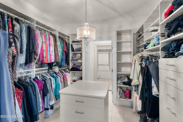 walk in closet with light tile patterned floors and a notable chandelier