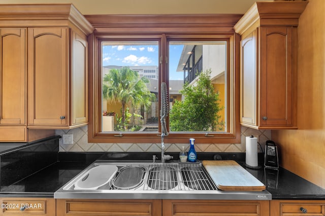 kitchen featuring backsplash, a wealth of natural light, and sink