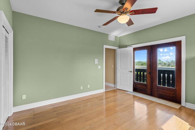 unfurnished bedroom with ceiling fan, light wood-type flooring, and french doors