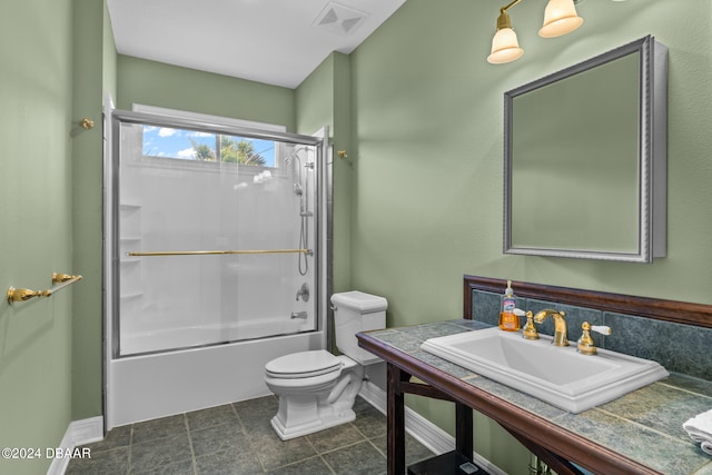 full bathroom with toilet, bath / shower combo with glass door, sink, and tile patterned flooring