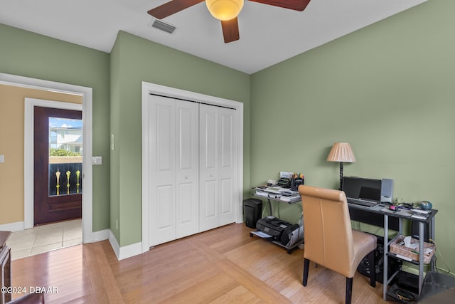 home office with ceiling fan and light hardwood / wood-style flooring