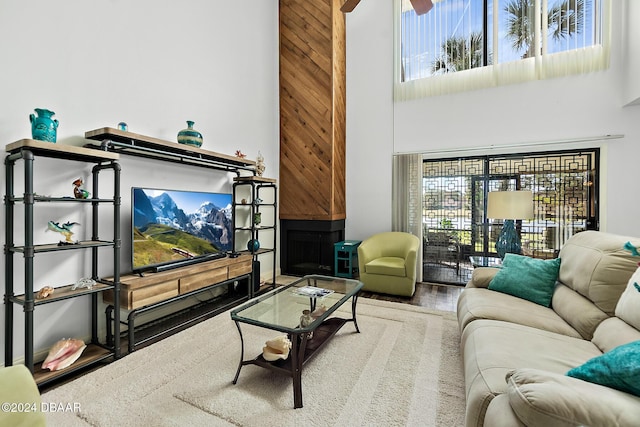 living room featuring a towering ceiling, hardwood / wood-style flooring, and ceiling fan