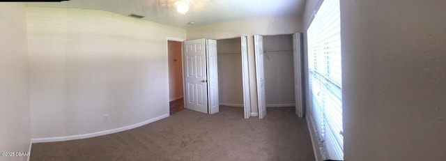 1975 Red Cedar Cir S, Daytona, FL 32119 - unfurnished bedroom featuring multiple closets, multiple windows, carpet floors, and baseboards