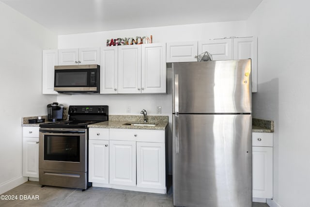 1318 San Jose Blvd, Daytona Beach, FL 32117 - kitchen featuring stainless steel appliances, a sink, white cabinets, and light stone counters