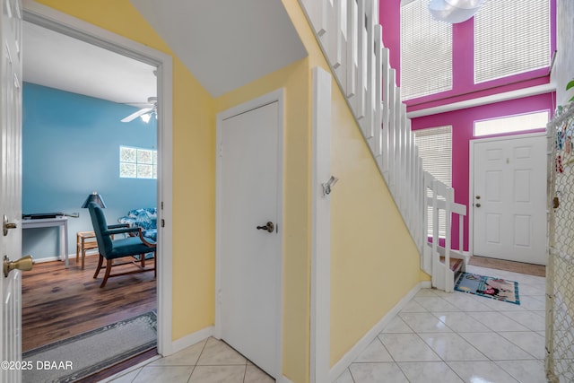 6361 Turtlemound Rd, New Smyrna Beach, FL 32169 - entrance foyer featuring tile patterned flooring, stairs, ceiling fan, and baseboards