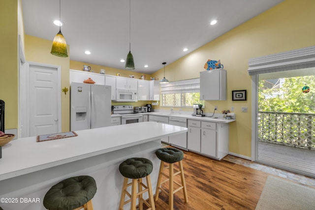 6361 Turtlemound Rd, New Smyrna Beach, FL 32169 - kitchen with white appliances, a kitchen breakfast bar, light countertops, a sink, and hanging light fixtures