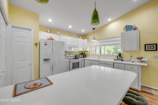 6361 Turtlemound Rd, New Smyrna Beach, FL 32169 - kitchen featuring pendant lighting, wood finished floors, white appliances, light countertops, and a sink