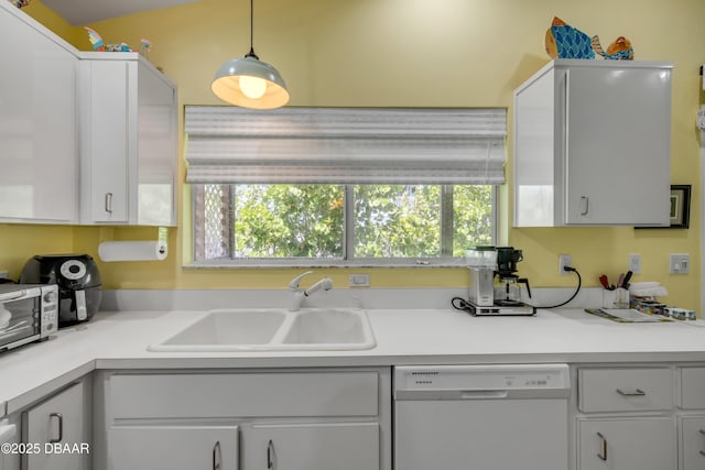 6361 Turtlemound Rd, New Smyrna Beach, FL 32169 - kitchen featuring white cabinets, a sink, dishwasher, light countertops, and pendant lighting