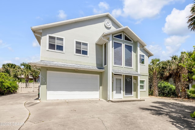 6361 Turtlemound Rd, New Smyrna Beach, FL 32169 - view of front of home featuring a garage, fence, stucco siding, and concrete driveway