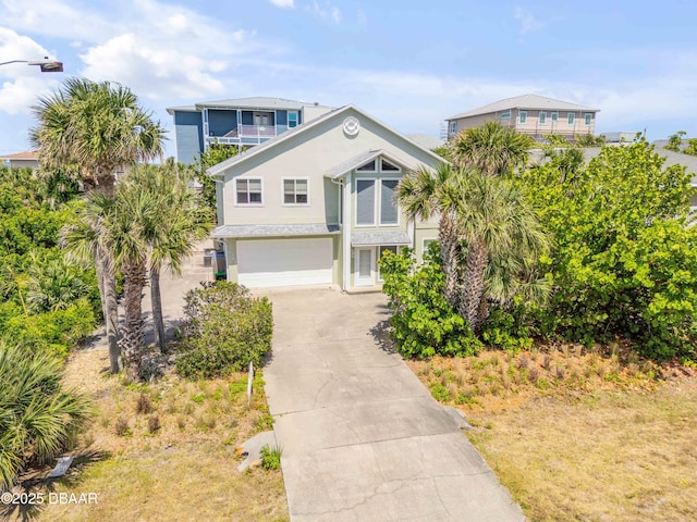 6361 Turtlemound Rd, New Smyrna Beach, FL 32169 - raised beach house featuring a garage, stucco siding, driveway, and a balcony
