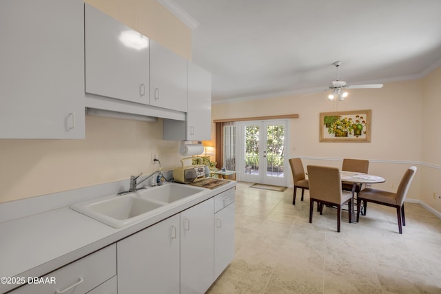 6361 Turtlemound Rd, New Smyrna Beach, FL 32169 - kitchen featuring white cabinets, french doors, ornamental molding, and a sink