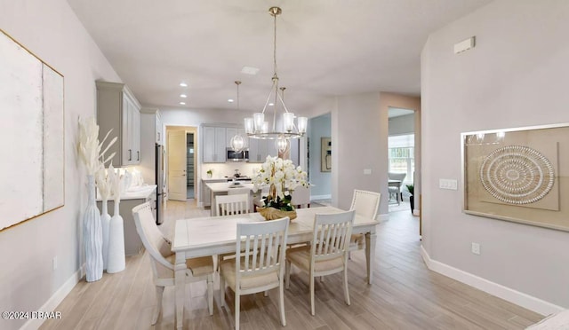 dining room with a notable chandelier and light hardwood / wood-style floors