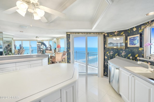 interior space featuring a water view, ceiling fan, light tile patterned floors, stainless steel dishwasher, and white cabinets