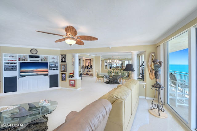 living room with ornate columns, ceiling fan with notable chandelier, light colored carpet, a water view, and crown molding