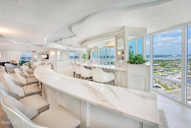 2545 S Atlantic Ave Unit 2107 2108, Daytona Beach Shores, FL 32118 - living area featuring a textured ceiling, tile patterned floors, and a water view