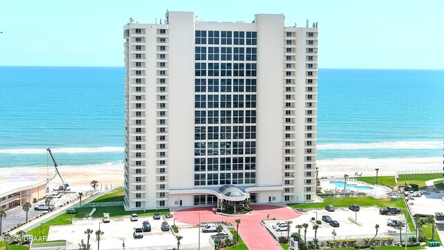 view of property featuring a water view and a beach view