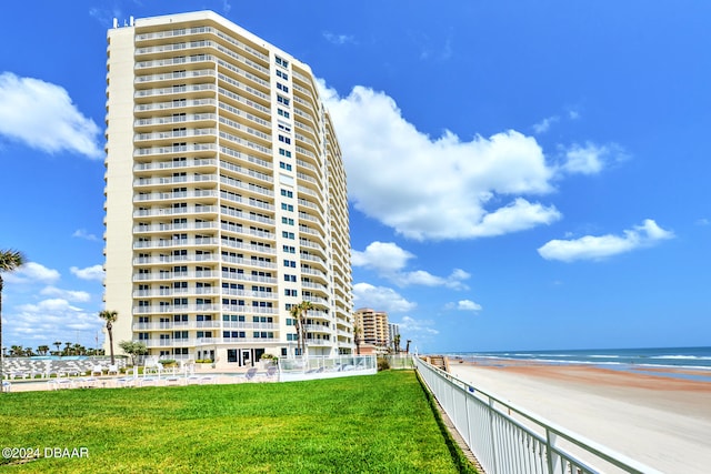 view of building exterior with a water view and a view of the beach