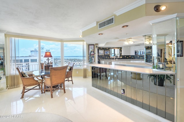 dining room featuring ceiling fan, light tile patterned floors, and ornamental molding