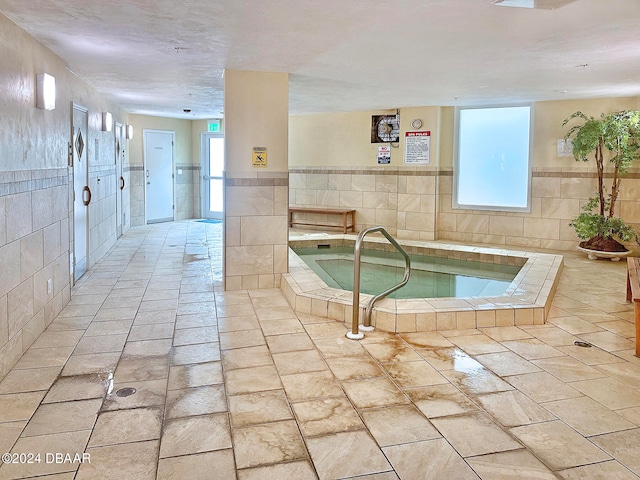 view of swimming pool with an indoor hot tub