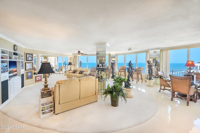 tiled living room with ceiling fan, a water view, a healthy amount of sunlight, and crown molding