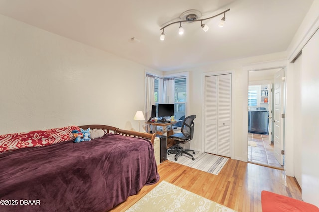 bedroom featuring track lighting and wood finished floors