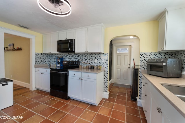 kitchen featuring electric range, stainless steel microwave, white cabinets, and light countertops