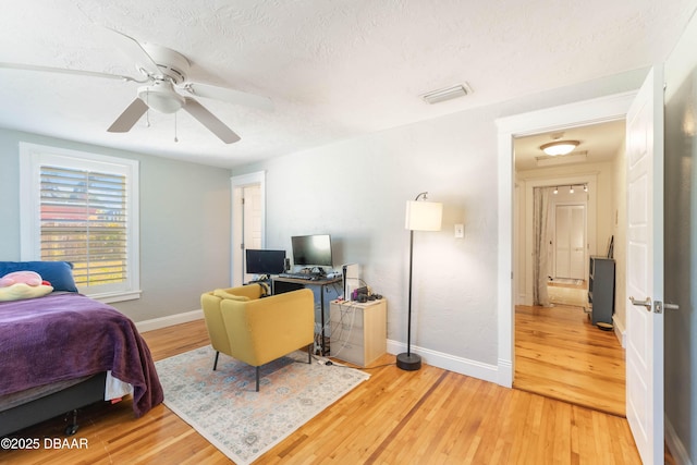 bedroom with visible vents, baseboards, and wood finished floors