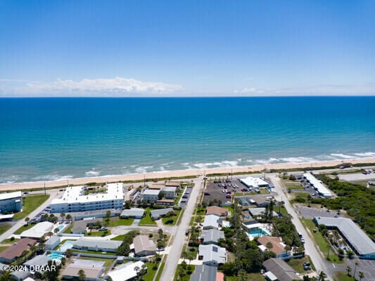 drone / aerial view featuring a water view and a beach view