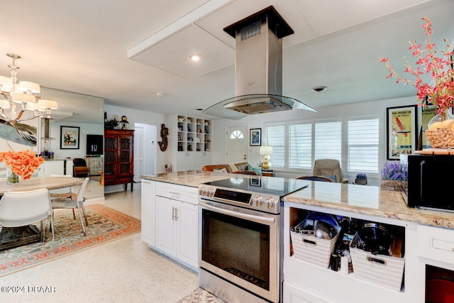 kitchen with island exhaust hood, white cabinetry, a notable chandelier, light stone countertops, and electric range