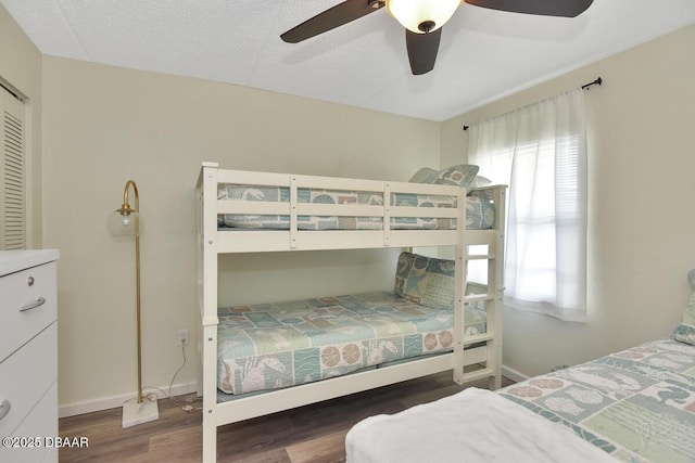 bedroom featuring wood finished floors, baseboards, and ceiling fan