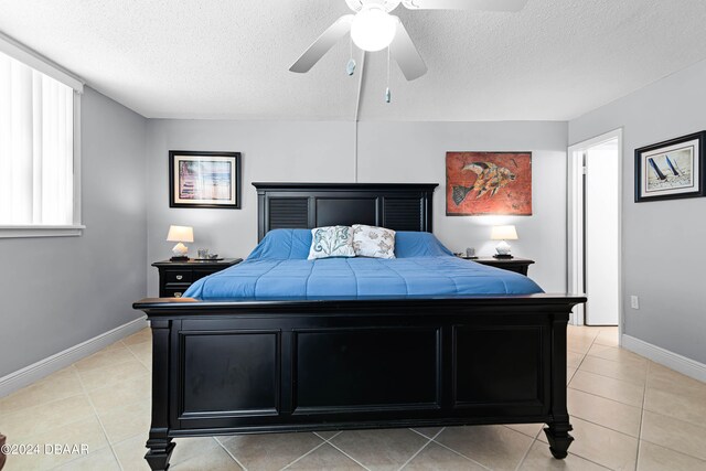 tiled bedroom with a textured ceiling and ceiling fan