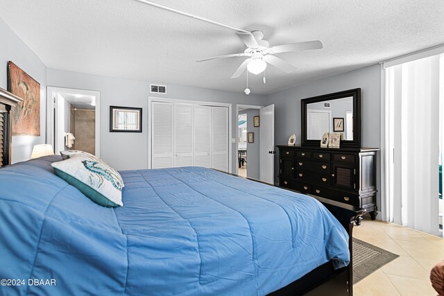 tiled bedroom featuring a closet, a textured ceiling, and ceiling fan