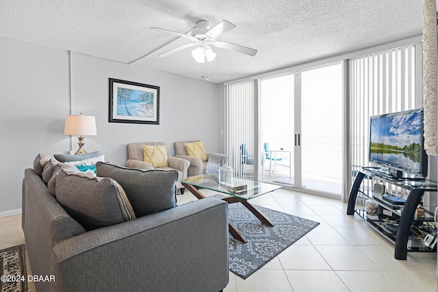 living room with expansive windows, light tile patterned flooring, ceiling fan, and a textured ceiling