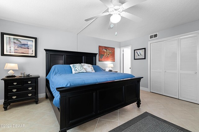 tiled bedroom featuring ceiling fan and a textured ceiling